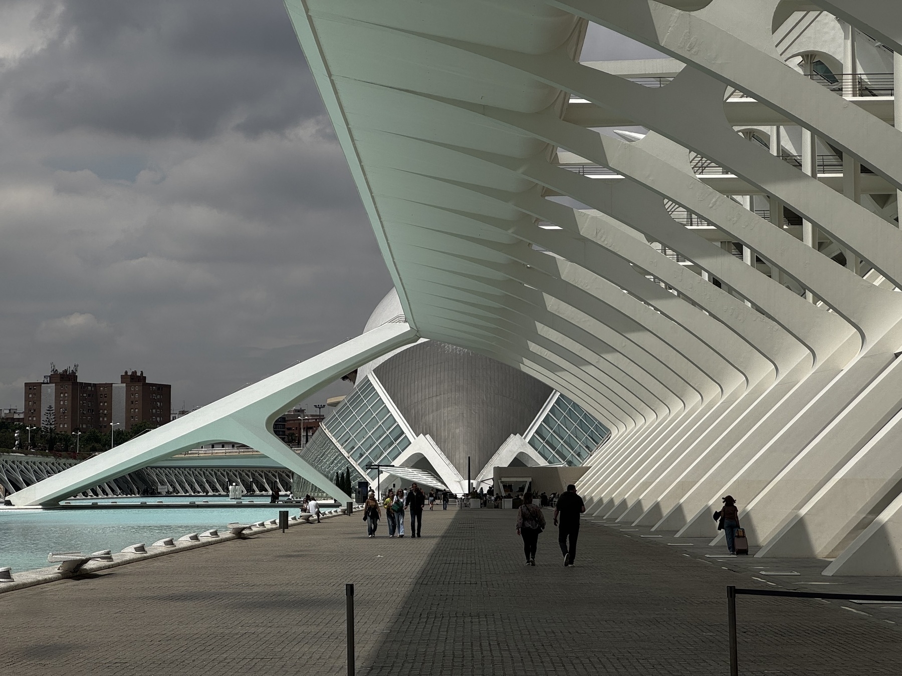 Visitors walk beneath the repeating skeletal arches of the Museu de les Ciències Príncipe Felipe in Valencia’s City of Arts and Sciences, a dramatic perspective that emphasizes the structure’s futuristic and organic form.
