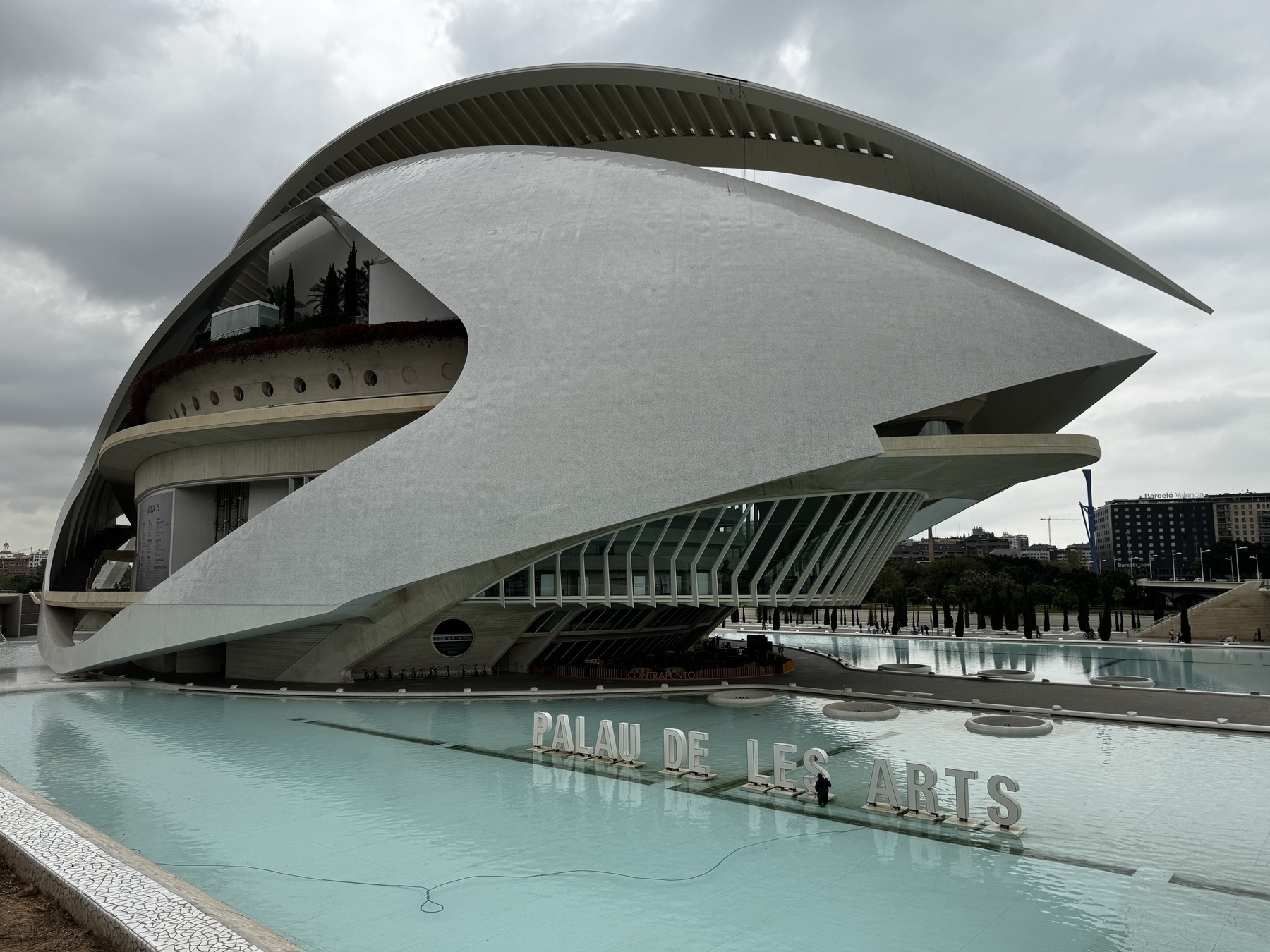 The Palau de les Arts Reina Sofía opera house in Valencia’s City of Arts and Sciences, with its soaring curves and sail-like roof, dramatically poised above the reflecting pool—echoing nautical forms and futuristic aesthetics.