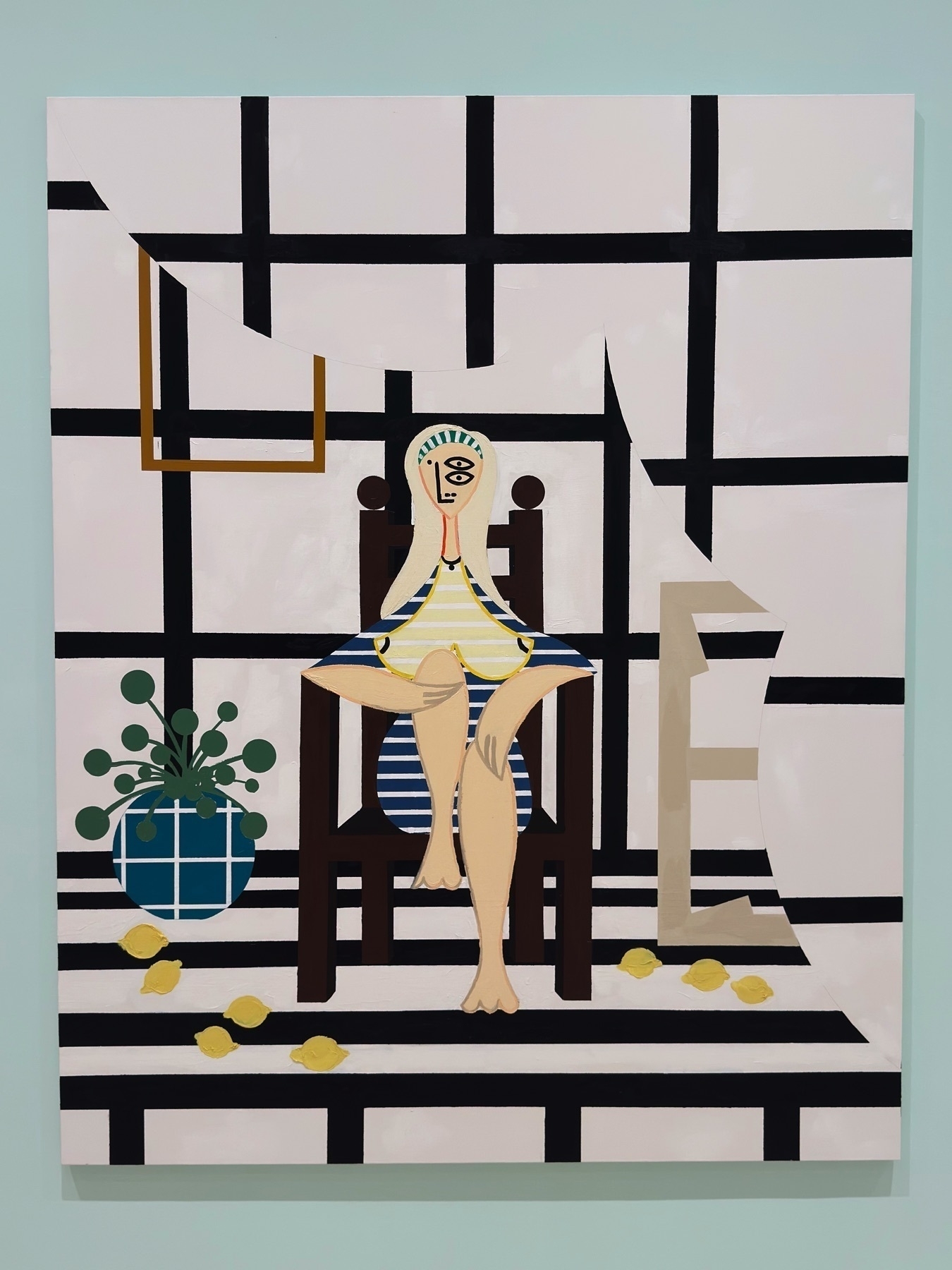 Contemporary painting of a stylized female figure seated on a wooden chair in a patterned black-and-white room. The background is composed of grid-like walls and a scattered arrangement of lemons and plants, blending figuration with decorative abstraction.